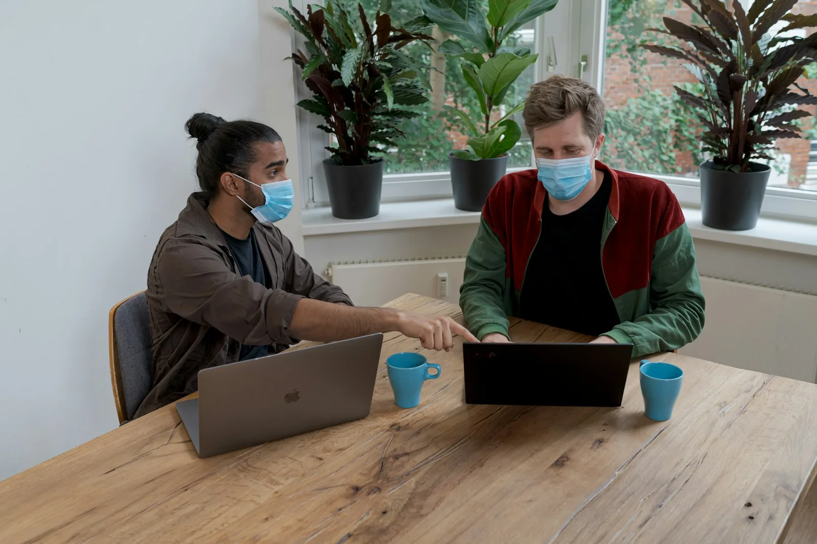 Two people meeting one-on-one at a table with a laptop.