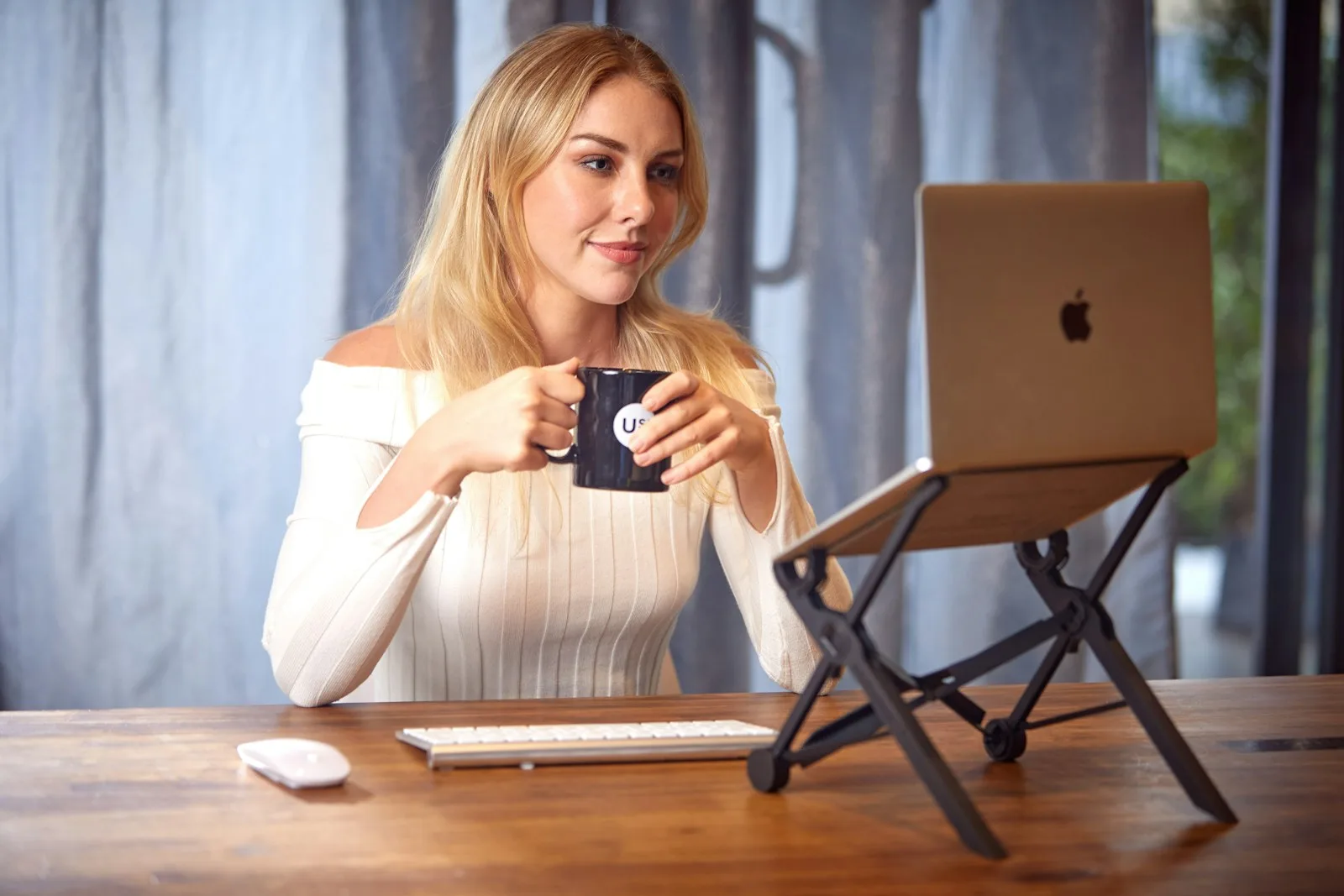 Young professional working on a laptop with coffee at a café table.